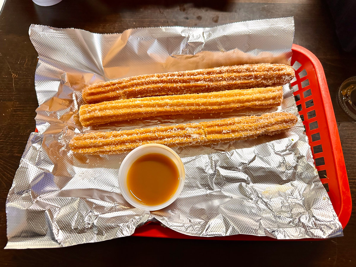 churros on foil in a red plastic container